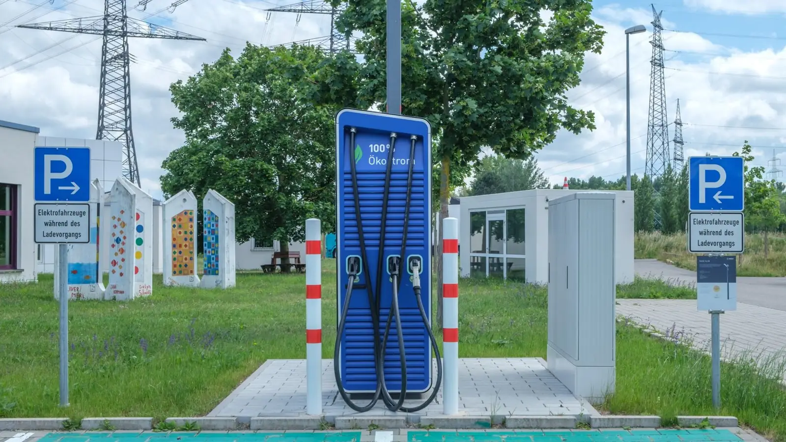 Elektroauto mit geöffneter Motorhaube und Ladekabel an der Ladesäule