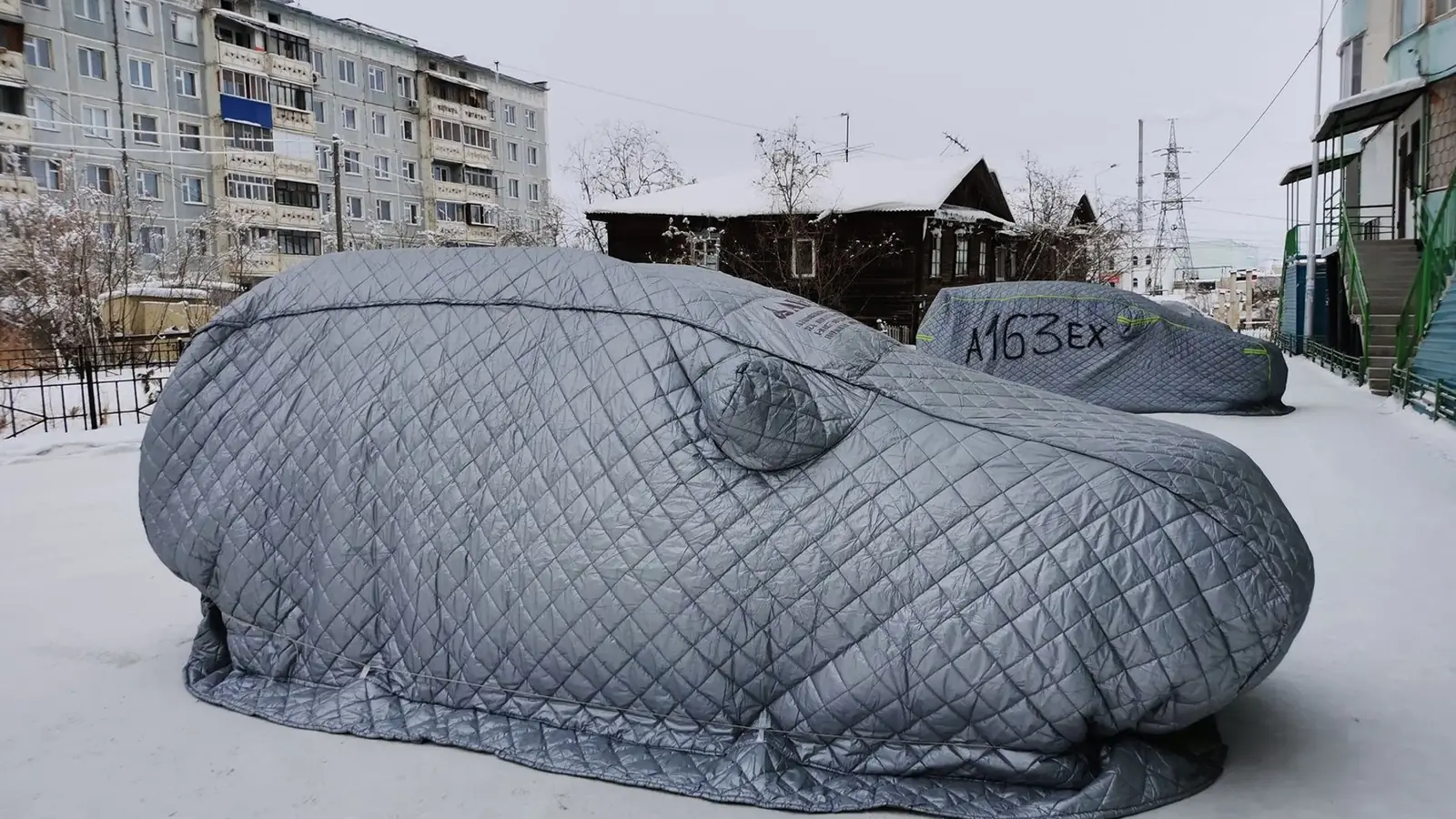 Mit atmungsaktiver Abdeckung geschütztes Auto in einer Garage im Winter